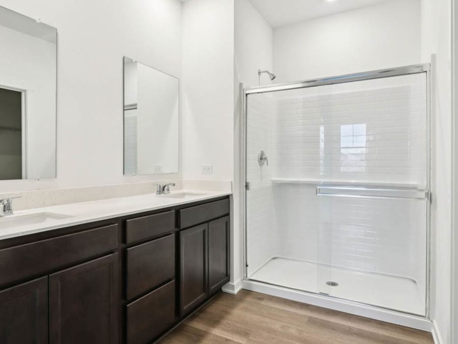 Baño principal con doble lavabo y regadera con vidrio (foto del constructor)
